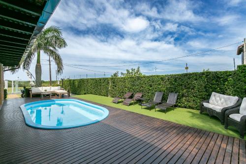a backyard with a pool and chairs and a fence at RJ Residencial Beira Mar in Palhoça