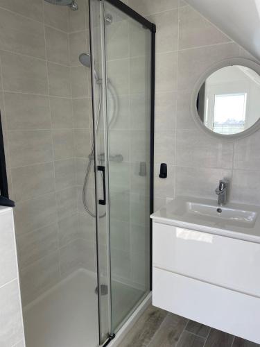 a bathroom with a shower and a sink at Ty Marie Neiz Vran - Villa luxe vue mer, 80 mètres de la plage in Kerlouan