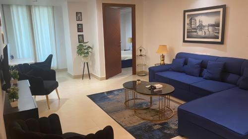 a living room with a blue couch and a table at Gold Crest Mall Luxury Apartments by NestNow in DHA Phase 4 Lahore in Lahore