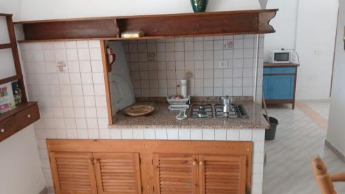 a dollhouse kitchen with a sink and a stove at La casa dei Nonni in Carloforte