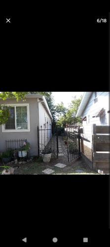 a white house with a gate in front of it at Ping's Tiny Home self-check in & out private in Merced