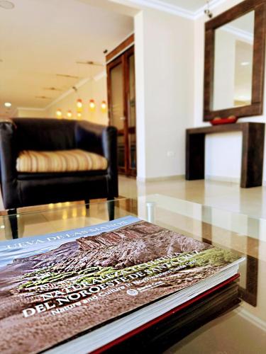 a living room with a couch and a book on a table at Hotel Aire de Patagonia in Río Gallegos