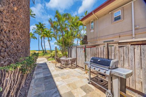 a barbecue on a patio next to a fence at Hale Kai O'Kihei 118 in Kihei