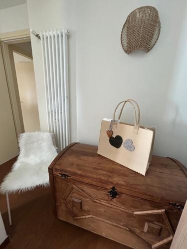 a bag sitting on top of a wooden chest at Maison Du Coeur Champoluc - Spa, Gym e aree relax in Champoluc