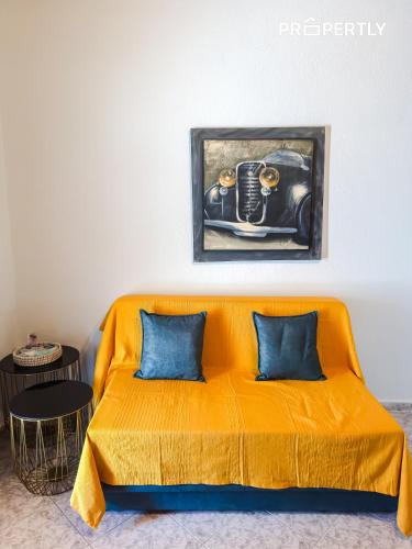 an orange couch with blue pillows in a room at Cypress Seaside Apartment #PROPERTLY in Nea Kallikrateia