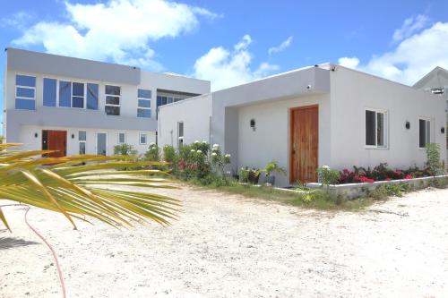 a white house with a palm tree in front of it at Ocean Pearl - Getaway Modern Villa W Pool in Long Bay Hills