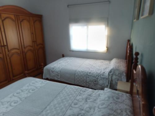 a bedroom with two beds and a window at Villasultana 1 in Chipiona