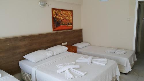 a room with two beds with white towels on them at Ozgun Apart Hotel in Kuşadası