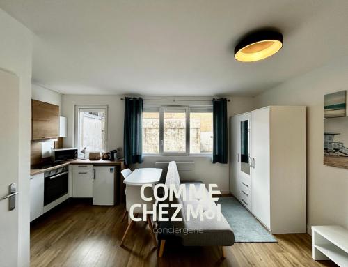 a kitchen with white cabinets and a table in a room at Studio Le Petit Placieux, Garage Gratuit sur place in Nancy
