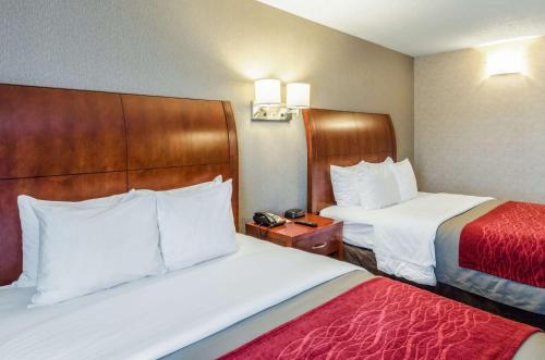 a hotel room with two beds and a telephone at Comfort Inn & Suites West Springfield in West Springfield