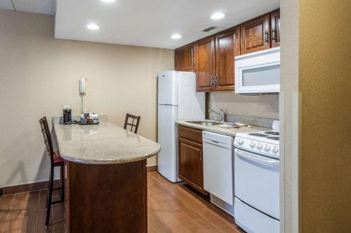 a kitchen with a white refrigerator and a counter at Comfort Inn & Suites West Springfield in West Springfield