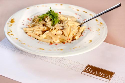 a bowl of pasta with a spoon on a table at Blanca Hotel in Izmir