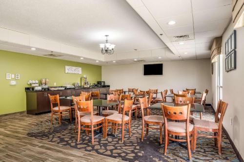 a dining room with tables and chairs and a counter at Sleep Inn & Suites Jacksonville near Camp Lejeune in Jacksonville