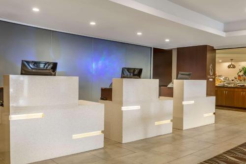 a lobby with white reception desks and a kitchen at Radisson Hotel Southfield-Detroit in Southfield