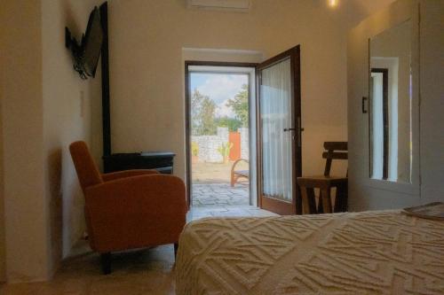 a bedroom with a bed and a chair and a door at Dimora Dei Semplici in Ostuni