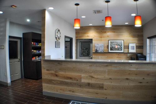 a bar in a restaurant with wooden walls and lights at Country Inn & Suites by Radisson, Topeka West, KS in Topeka