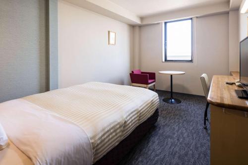a hotel room with a bed and a desk at Comfort Inn Niigata Kameda in Niigata