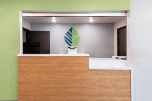 an office with a reception desk with a blue and green at WoodSpring Suites Waco South in Waco