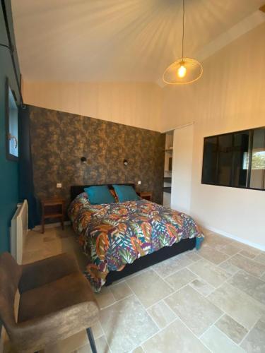 a bedroom with a bed and a chair at La p'tite hirondelle in Les Magnils-Reigniers