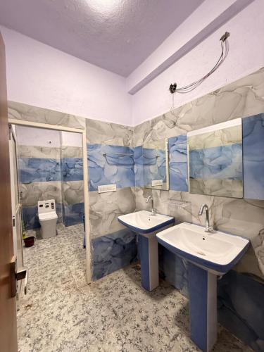 a bathroom with two sinks and a mirror at Hotel Shree Radhe Krishna in Ujjain