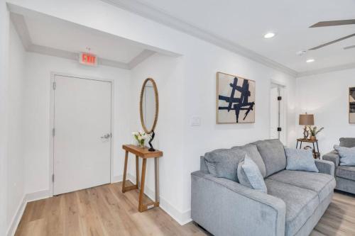 a living room with a gray couch and a mirror at Spectacular Suites Sleep 20 Near Fq W Pool in New Orleans