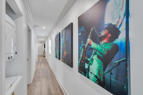 a hallway with paintings of a musician playing a saxophone at Spectacular Suites Sleep 20 Near Fq W Pool in New Orleans