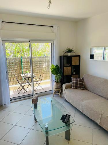 un salon avec un canapé et une table en verre dans l'établissement Apartment 2 steps from Bergerie Beach!, à Hyères