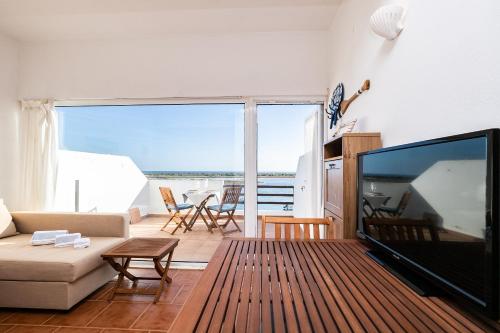 a living room with a large flat screen tv at NEW !! Studio Ria Formosa - Cabanas de Tavira in Cabanas de Tavira