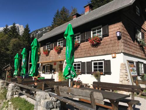 a group of green umbrellas in front of a building at Planinski dom - Mihov dom na Vršiču in Kranjska Gora