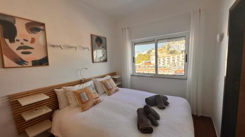Un dormitorio con una gran cama blanca con ventana. en Casino 5, en Carvoeiro