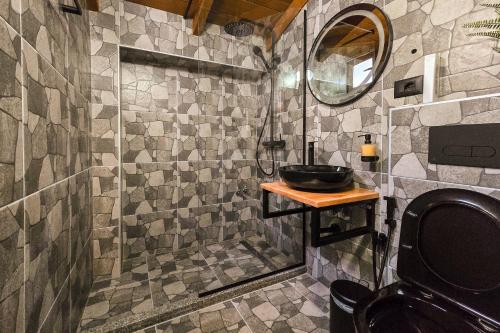 y baño con lavabo y ducha acristalada. en Silver Hill Guesthouse, en Gjirokastra