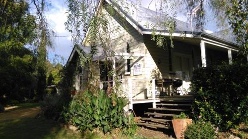 a white house with some plants in front of it at The Old Church Bed and Breakfast in Boonah