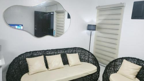 ein Wohnzimmer mit einem Stuhl und einem Spiegel in der Unterkunft Anna's cozy house in Angeles