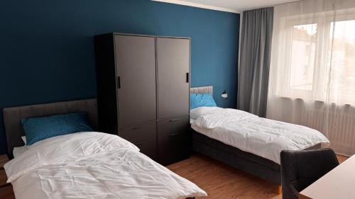 a bedroom with two beds and a large cabinet at ProStays Apartment in Mönchengladbach - 2 Schlafzimmer - 4 Betten in Mönchengladbach