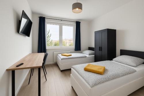 a small room with a bed and a desk and a window at Ideal für Monteure. 3 Zimmer Apartment mit Küche, Waschmaschine, WiFi usw... . in Nietleben