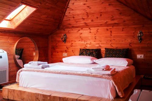 a bedroom with a bed in a log cabin at Silver Hill Guesthouse in Gjirokastër