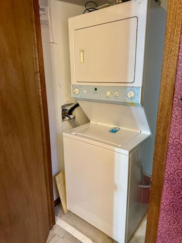 a small white refrigerator with a microwave on top of it at Mystical Haven Honeymoon Cabin in Sevierville