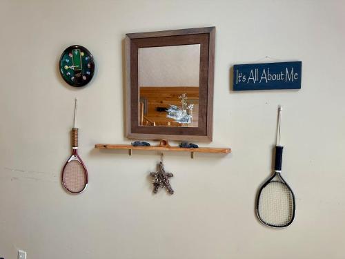 a wall with two tennis rackets and a mirror at Mystical Haven Honeymoon Cabin in Sevierville