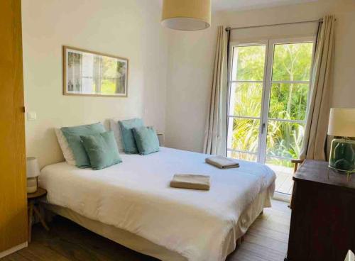 una camera da letto con un letto grande con due asciugamani sopra di Au cœur de Trégastel, noyée dans la végétation a Trégastel