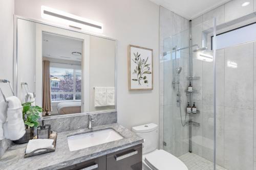 a white bathroom with a sink and a shower at Centrally Located Luxury Home with Views and Cinema in Vancouver