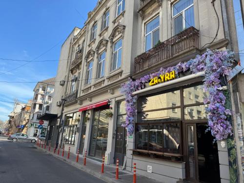 a store with purple flowers on the front of a building at Mianelly Center in Constanţa