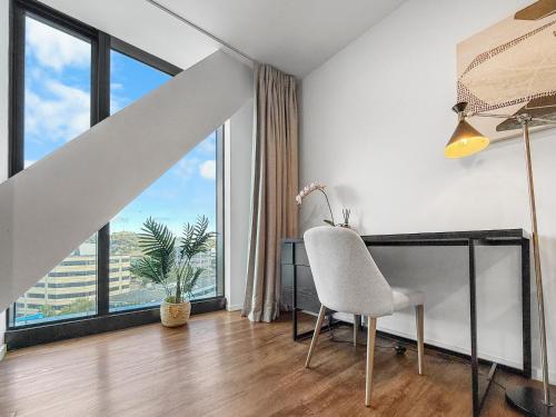 an office with a chair and a desk with a window at Ellerslie Sanctuary- Modern, quality apartment in Auckland