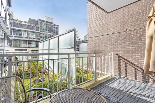 a balcony with two chairs and a brick building at Modern, central Vancouver suite in Vancouver