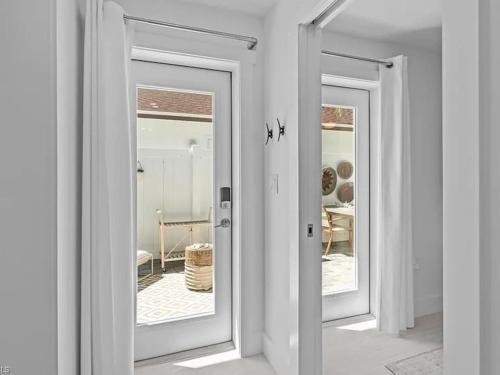 een kamer met twee spiegels en een kamer met een tafel bij Sand And Sea Bungalow in Naples