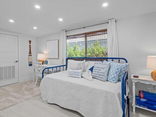 een slaapkamer met een bed met kussens en een raam bij Sand And Sea Bungalow in Naples
