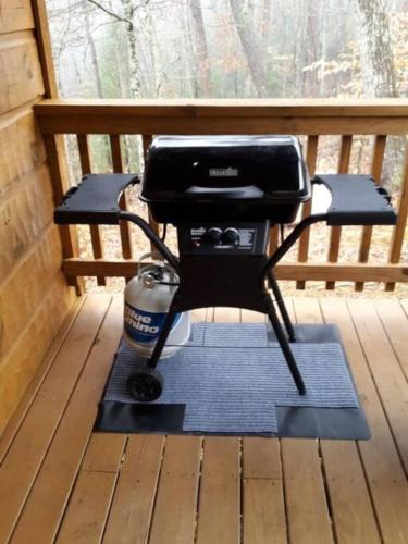 a grill sitting on a porch in front of a window at Jungle Safari Honeymoon Cabin in Sevierville