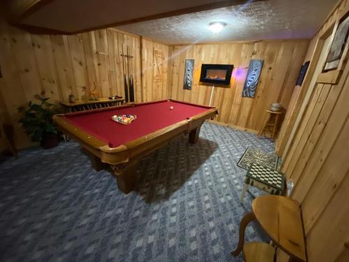 a pool table in the middle of a room at Jungle Safari Honeymoon Cabin in Sevierville