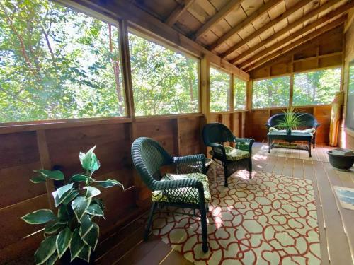 a screened in porch with chairs and a plant at Jungle Safari Honeymoon Cabin in Sevierville