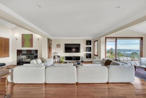 a living room with white furniture and a fireplace at The West Vancouver Getaway Estate 5 Bedrooms in West Vancouver