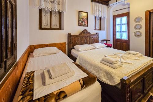 1 dormitorio con 2 camas y toallas. en Silver Hill Guesthouse, en Gjirokastra
